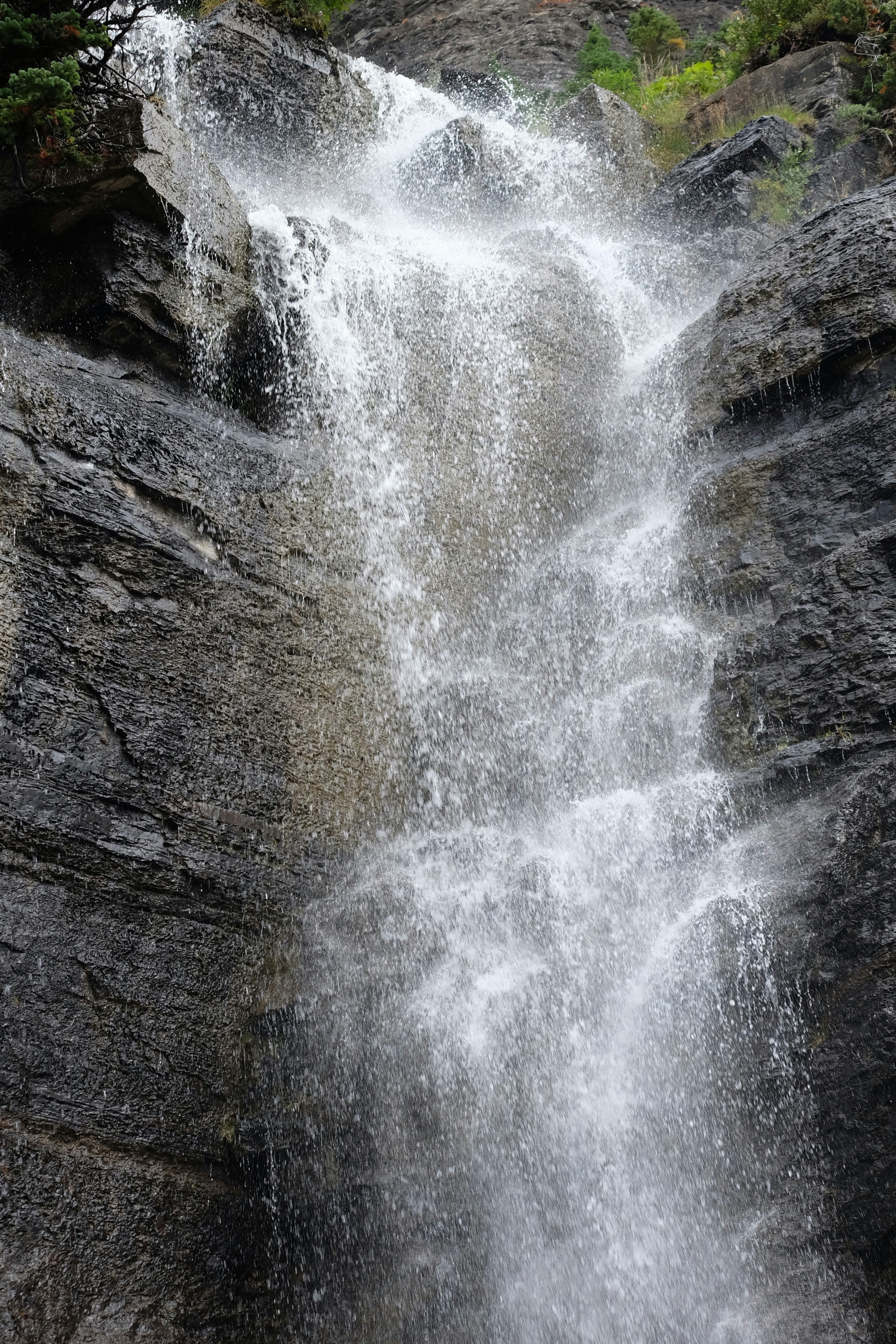 a waterfall with rocks and trees