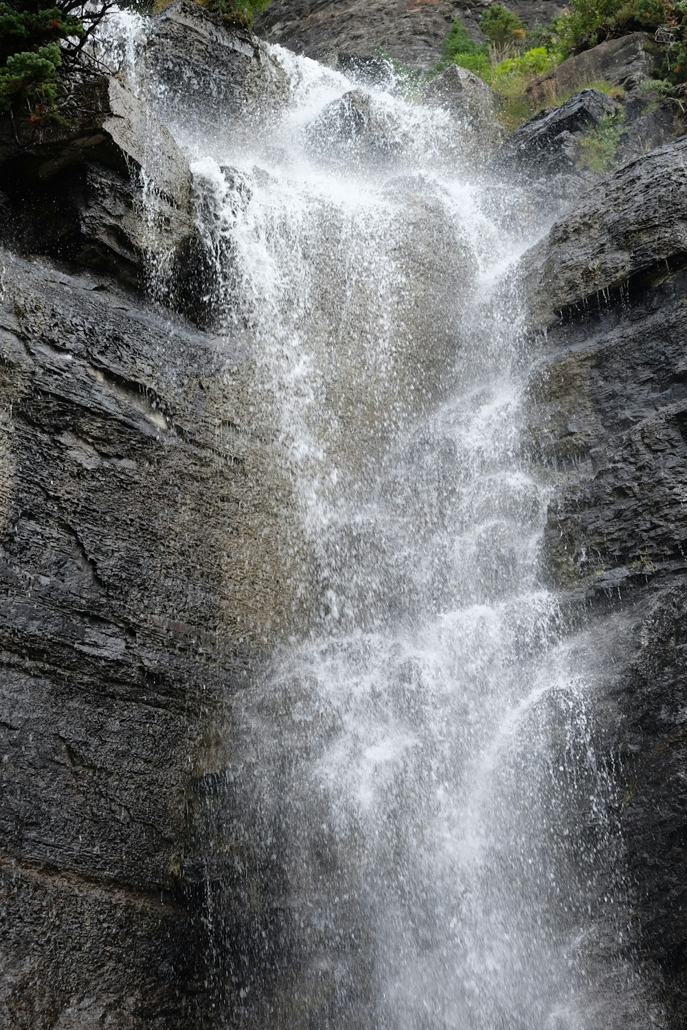 a waterfall with rocks and trees