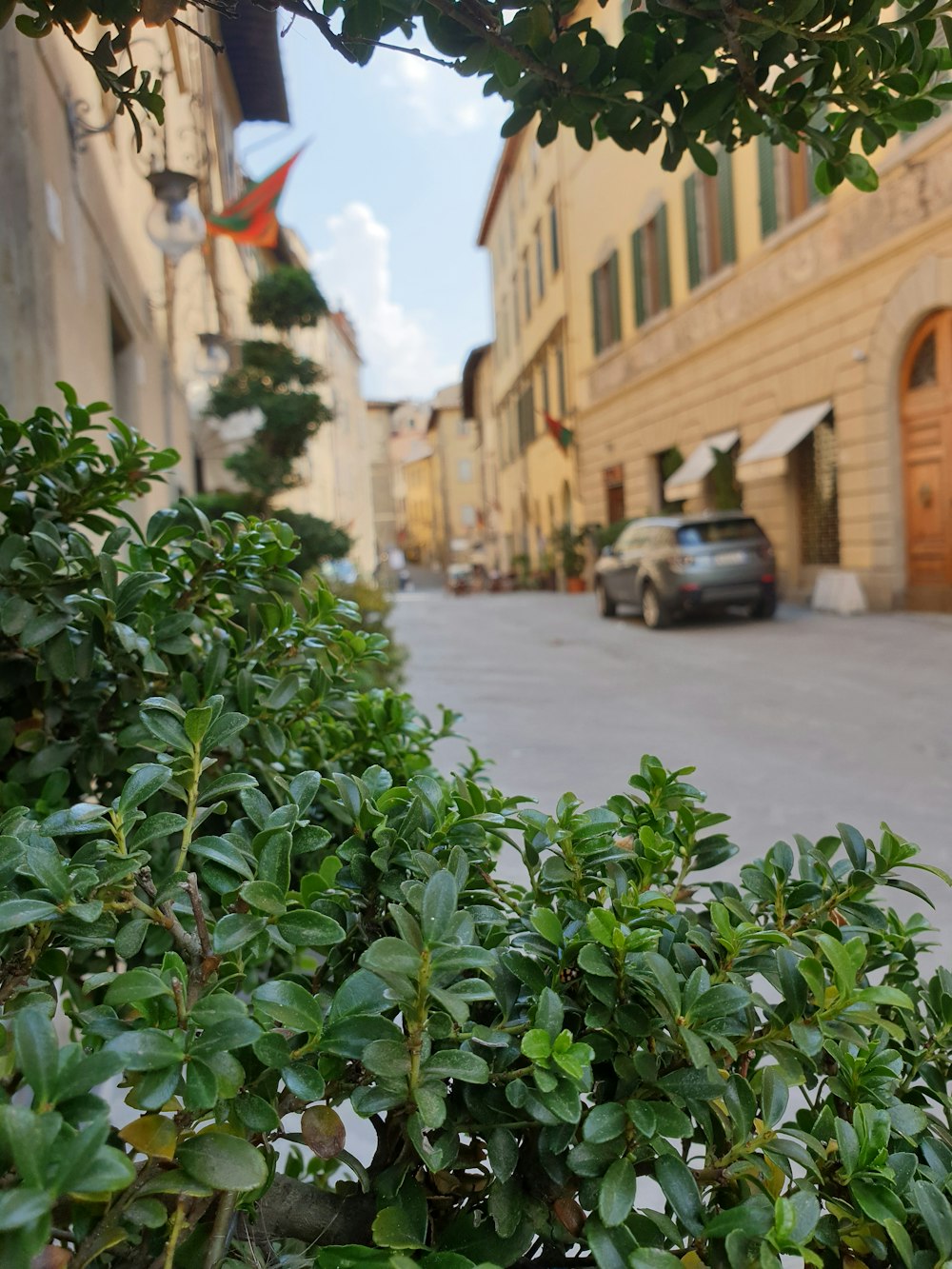 a street with a car parked on the side and a building on the other side