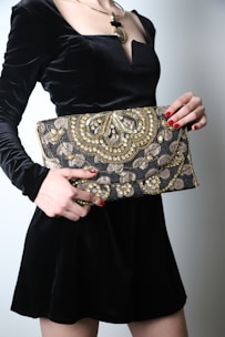 A festive clutch adorned with delicate embroidery and shimmering gold accents, perfect for celebrations.