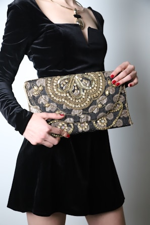 An elegant clutch bag with delicate embroidery placed on a vintage lace cloth.