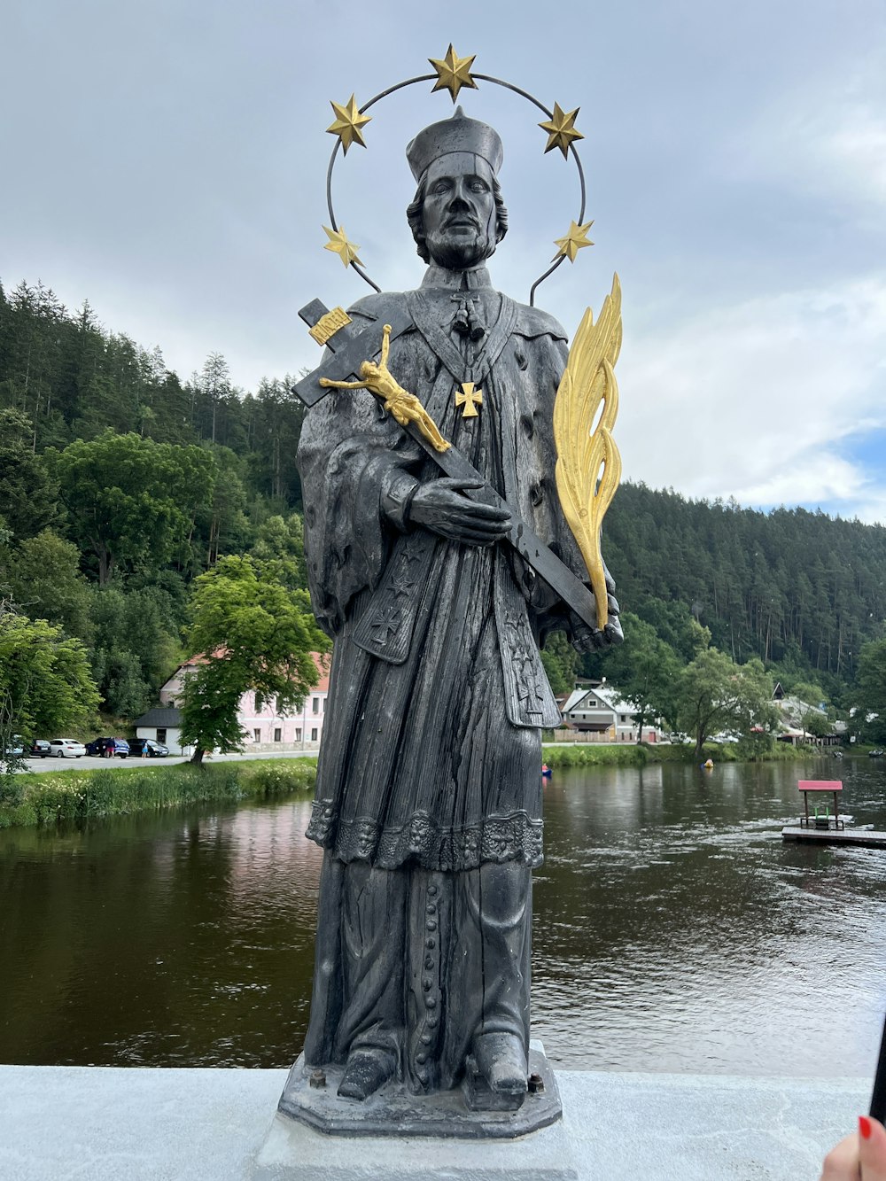 a statue of a person holding a staff and a crown