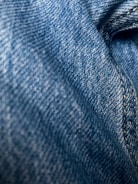 Close-up of rich blue denim fabric rolls stacked in a warehouse.