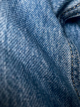 Close-up of rich indigo Japanese denim fabric with visible texture and stitching.