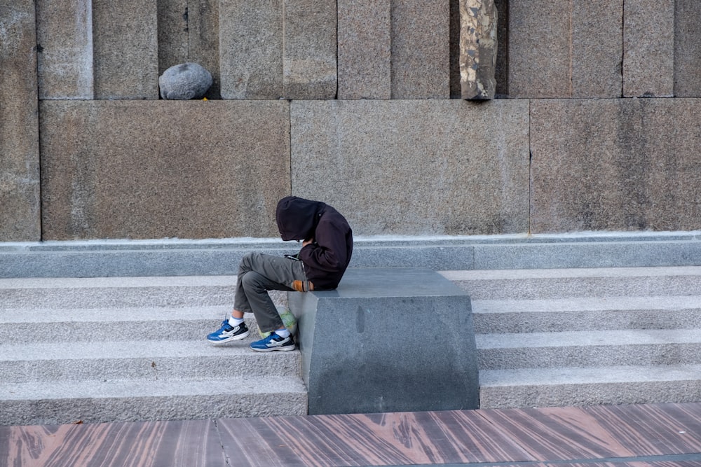 a person sitting on a stone bench