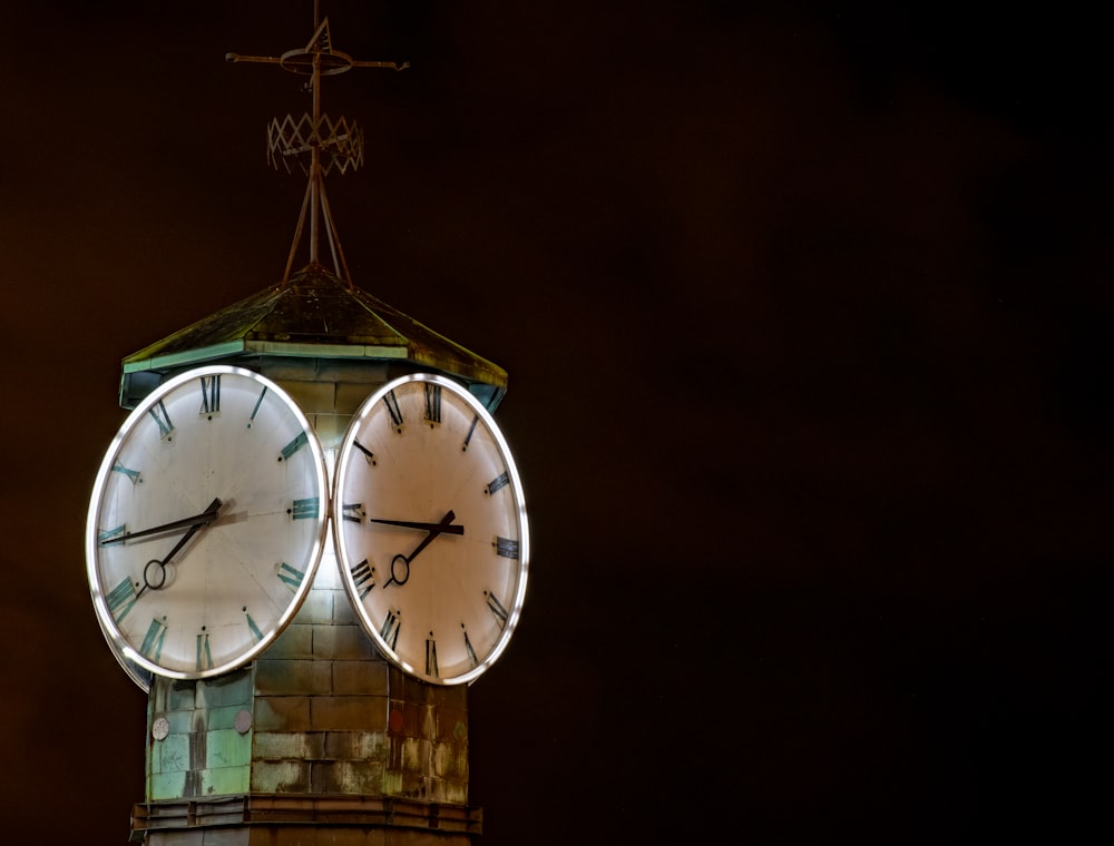 a clock tower with a weather vane