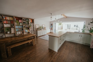 Modern kitchen area with oven and spacious dining table.
