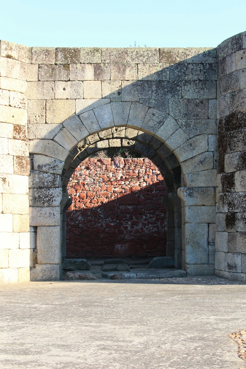 um arco de pedra com uma parede de tijolos