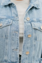 A casual outfit featuring light-wash jeans paired with a denim jacket in soft natural light.