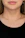 Close-up of a smiling woman wearing a minimalist gold necklace from Sundara Aura.