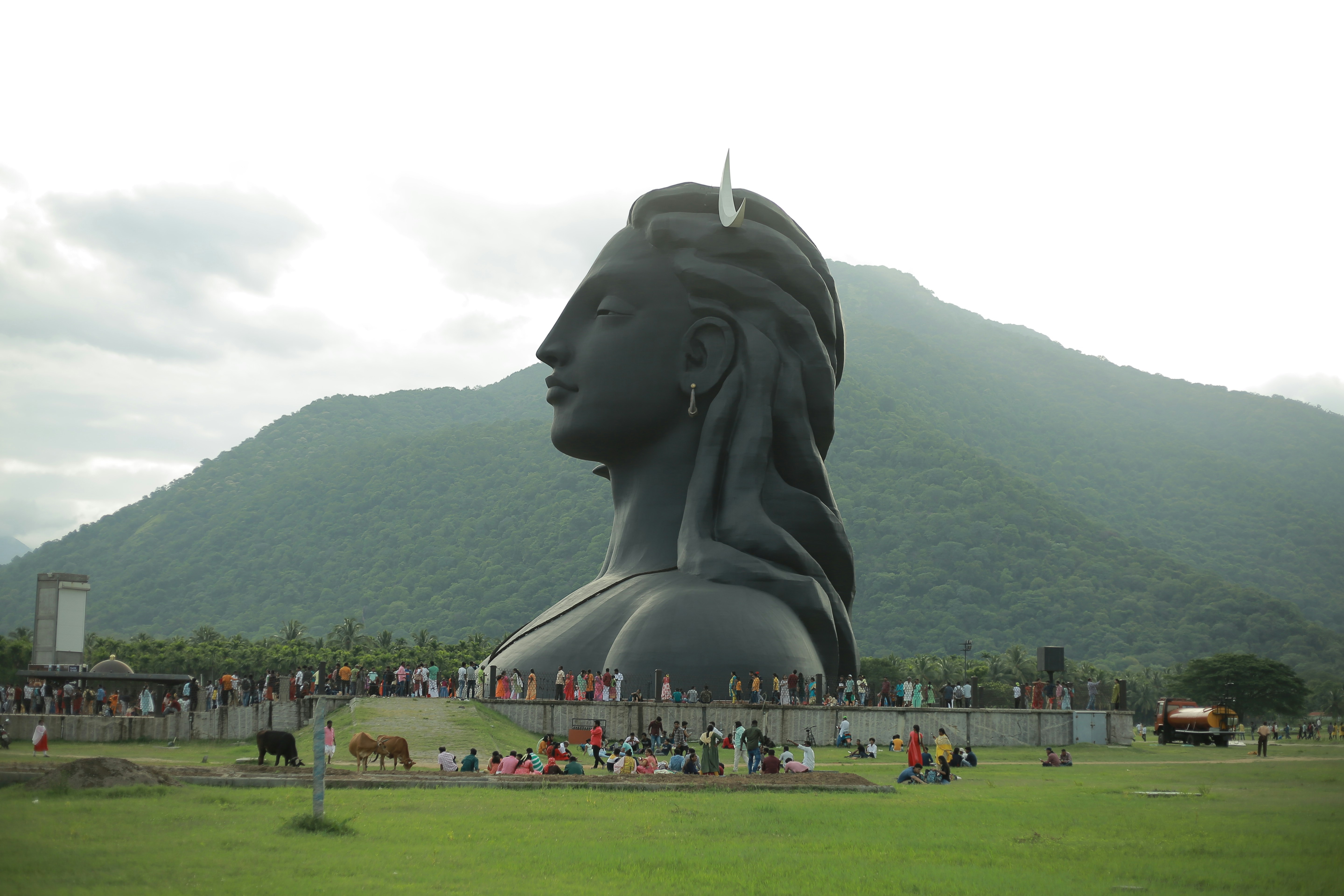 a large statue of a man's head on a grassy field
