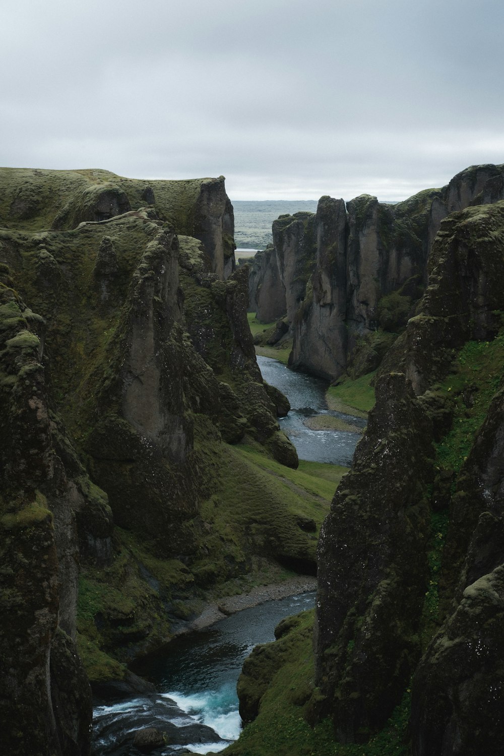 a rocky cliff with a river running through it