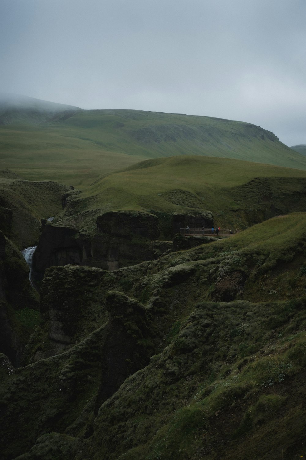 a group of people walking on a rocky hill