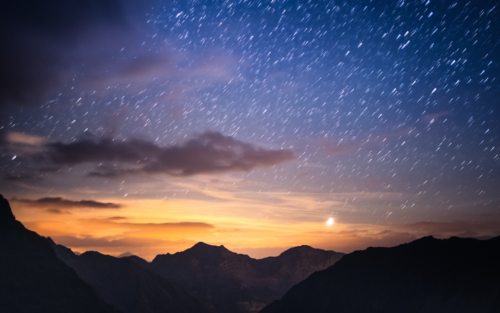um céu noturno estrelado sobre as montanhas