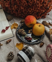 Cozy kitchen scene with jars of apple butter and autumn leaves on a wooden table.