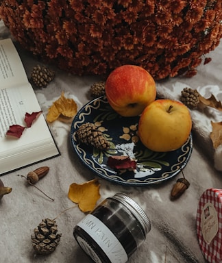 Cozy kitchen scene with jars of apple butter and autumn leaves on a wooden table.