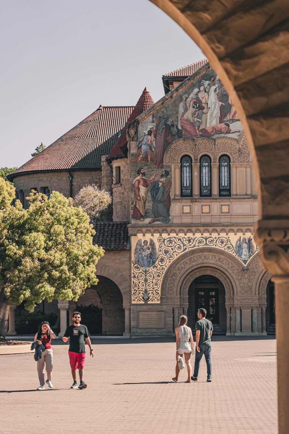 a group of people walking in front of a building with a large mural