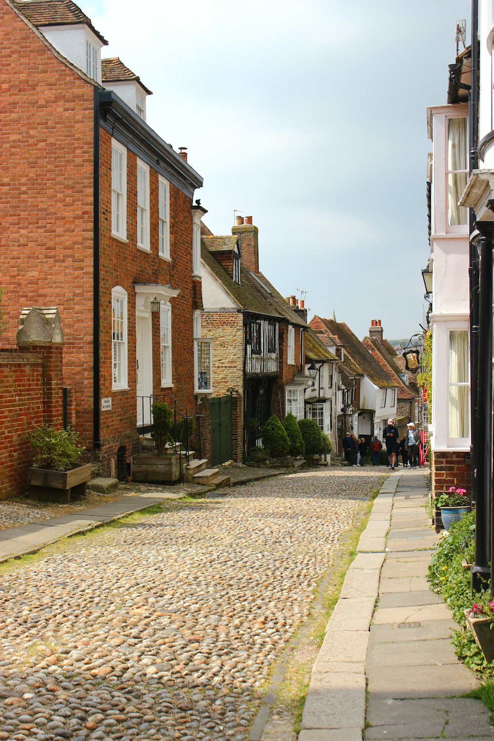 a cobblestone street between brick buildings