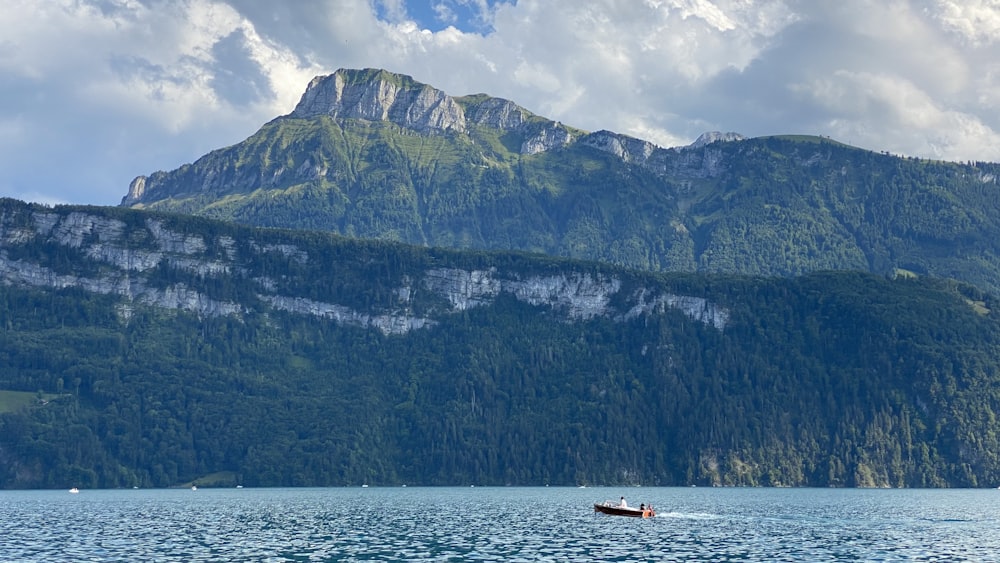 a boat in the water with a mountain in the background