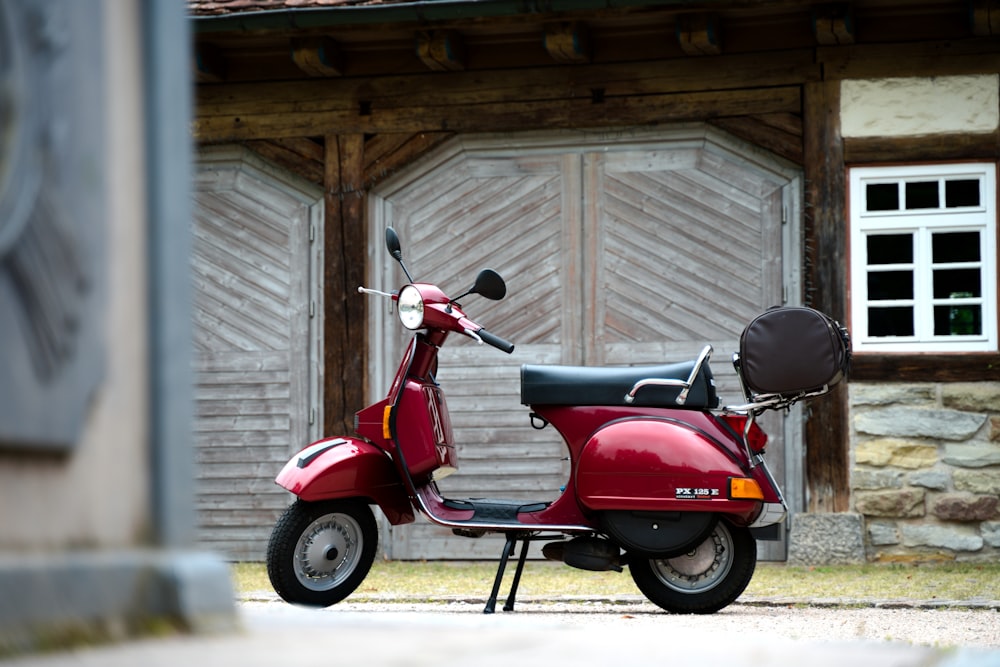 a red scooter parked outside a house