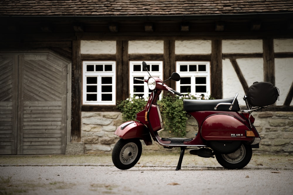 a red scooter parked in front of a house