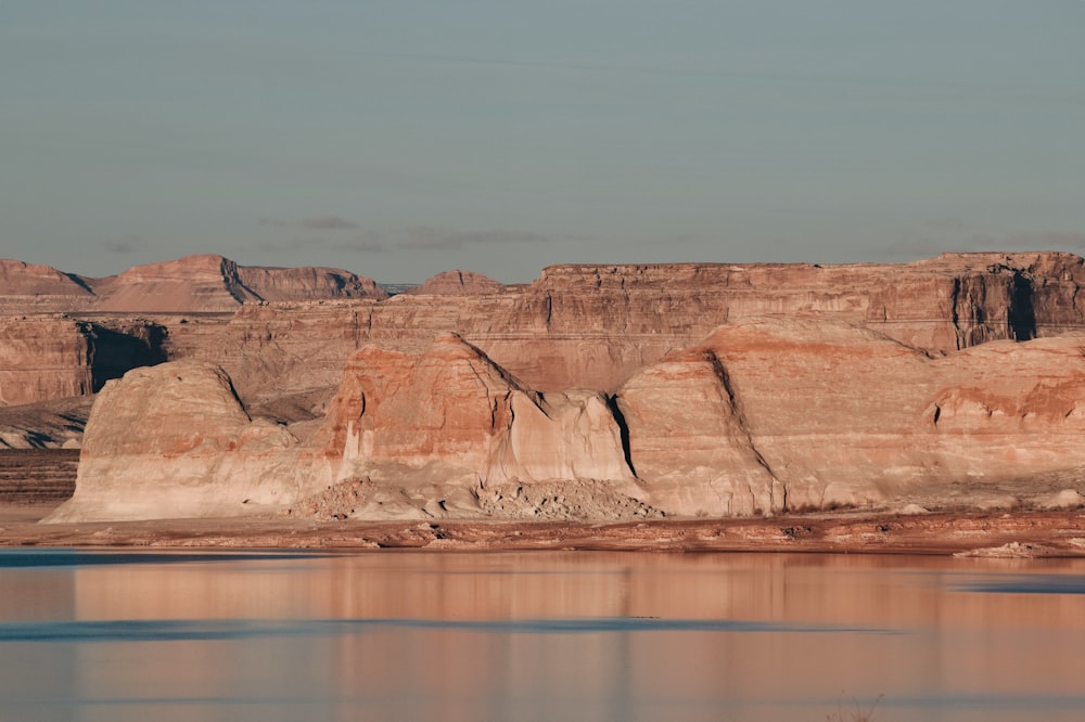 a body of water with a rocky cliff in the background