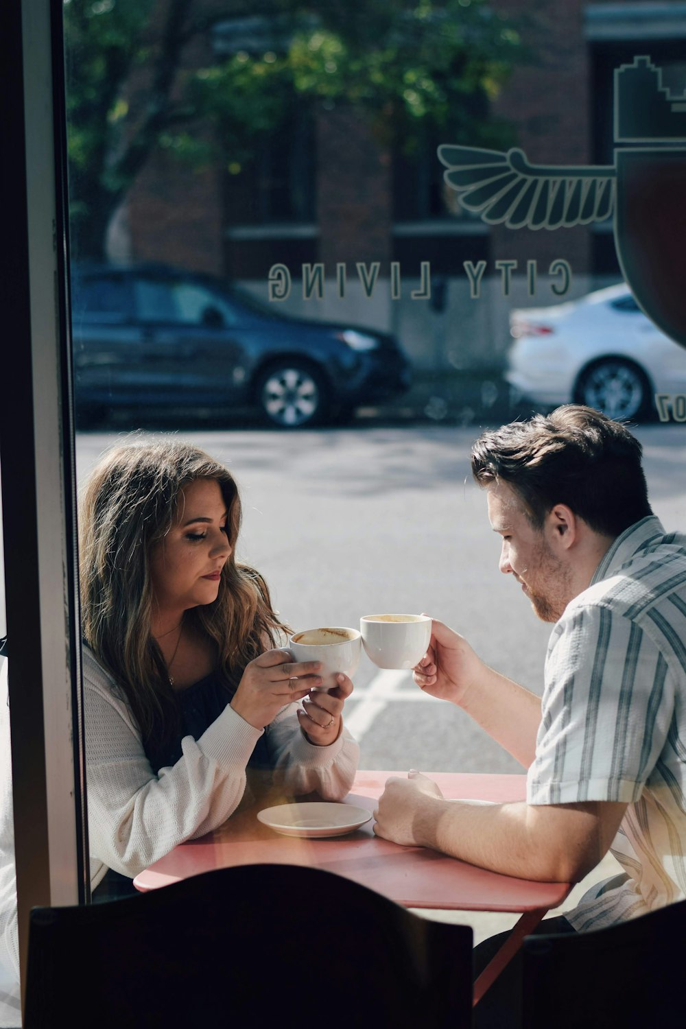 a man and a woman sitting at a table with coffee