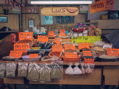 Friendly shop owner arranging Luna Láctea products on a colorful market stall in Zapopan.