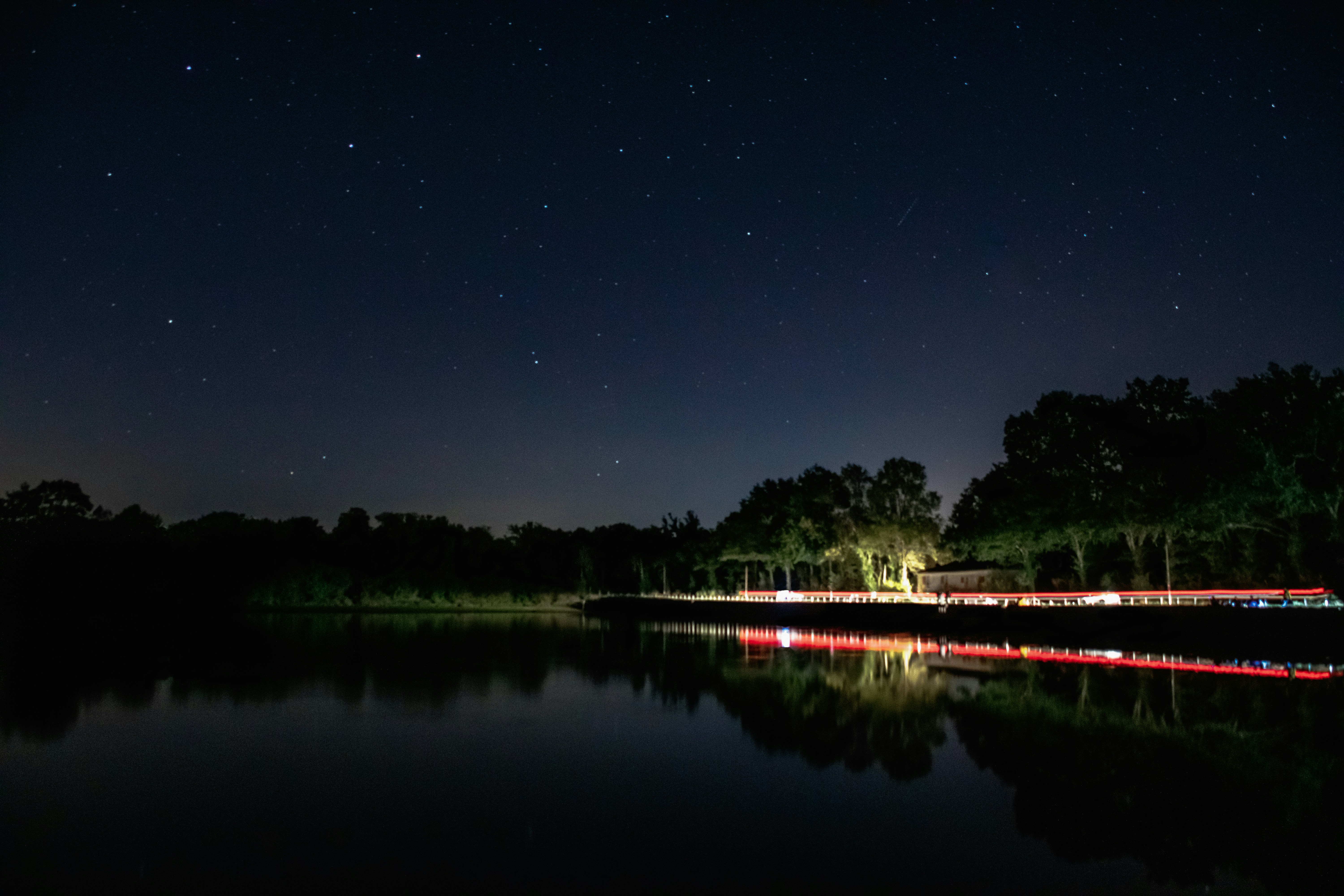 a body of water with trees and a building in the distance