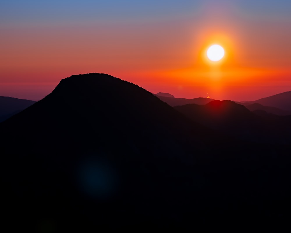 a sunset over a mountain