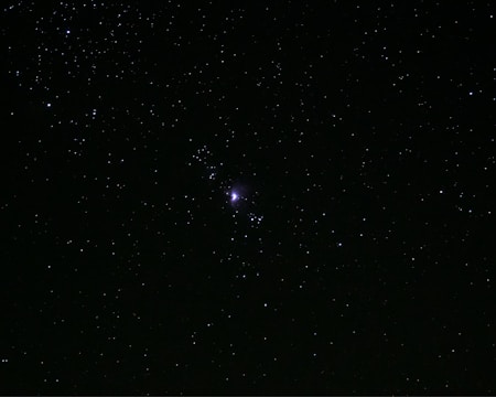 a starry night sky with a bright light in the middle with Gallery Arcturus in the background
