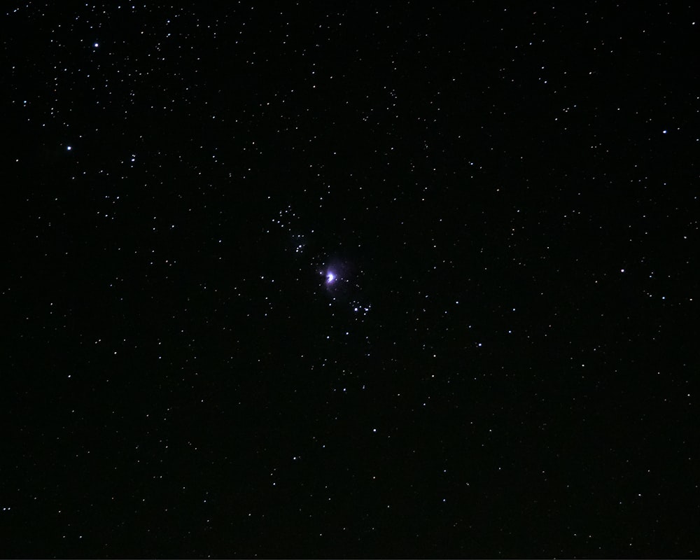 um céu noturno estrelado com uma luz brilhante no meio com a Galeria Arcturus ao fundo