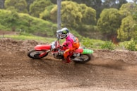 A vibrant red dirt bike kicking up dirt during a spirited off-road ride.