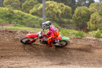 A vibrant red dirt bike kicking up dirt during a spirited off-road ride.