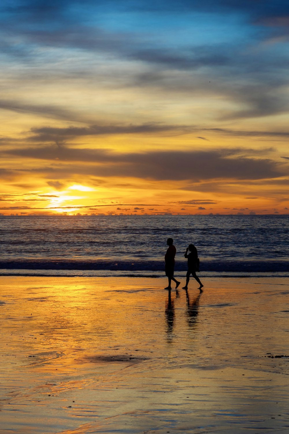 a couple people walking on a beach