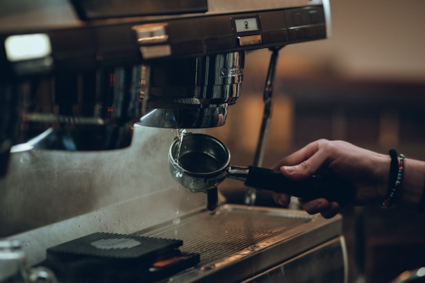 Close-up of a professional espresso machine being serviced by a technician in a cozy workshop.