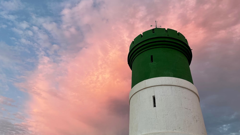 a lighthouse with a pink and blue sky