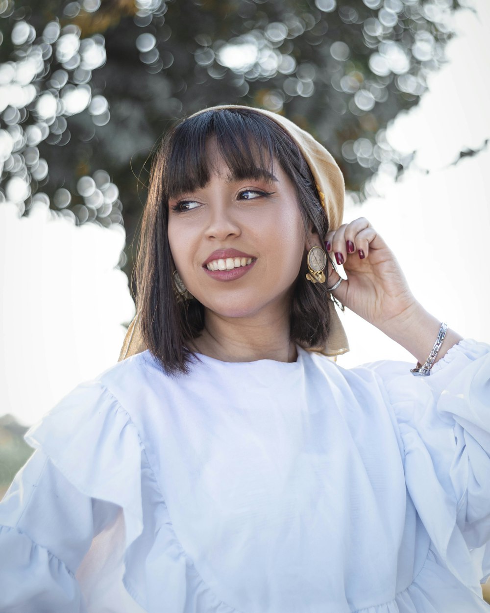 a woman smiling with her hand on her head