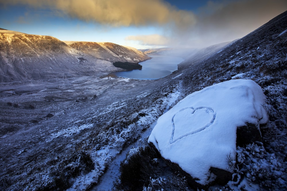 a snowy mountain with a lake