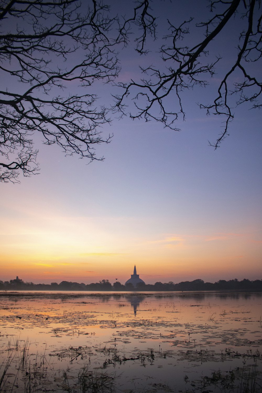 un plan d’eau avec une tour au loin