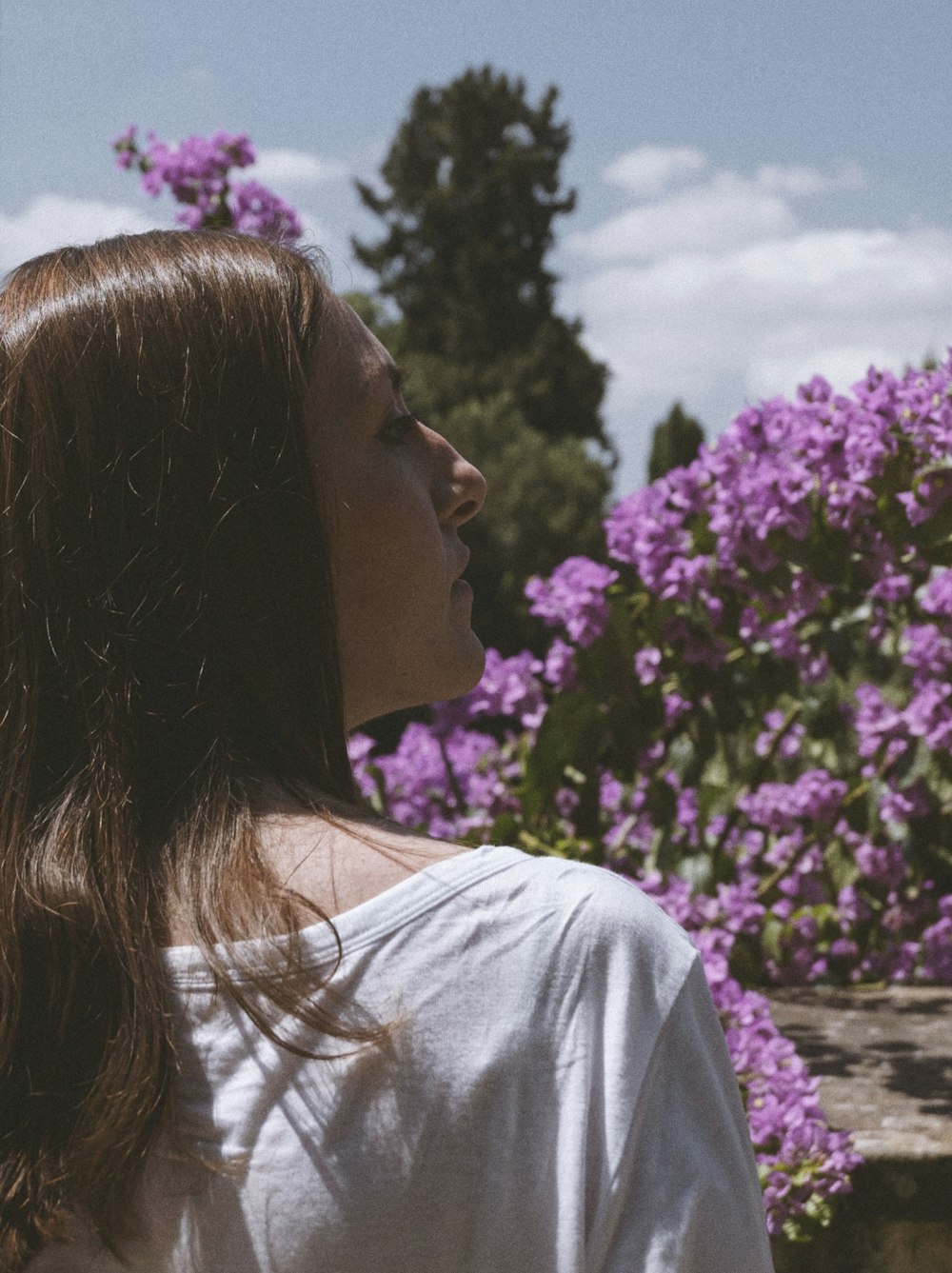 a woman looking at a flower