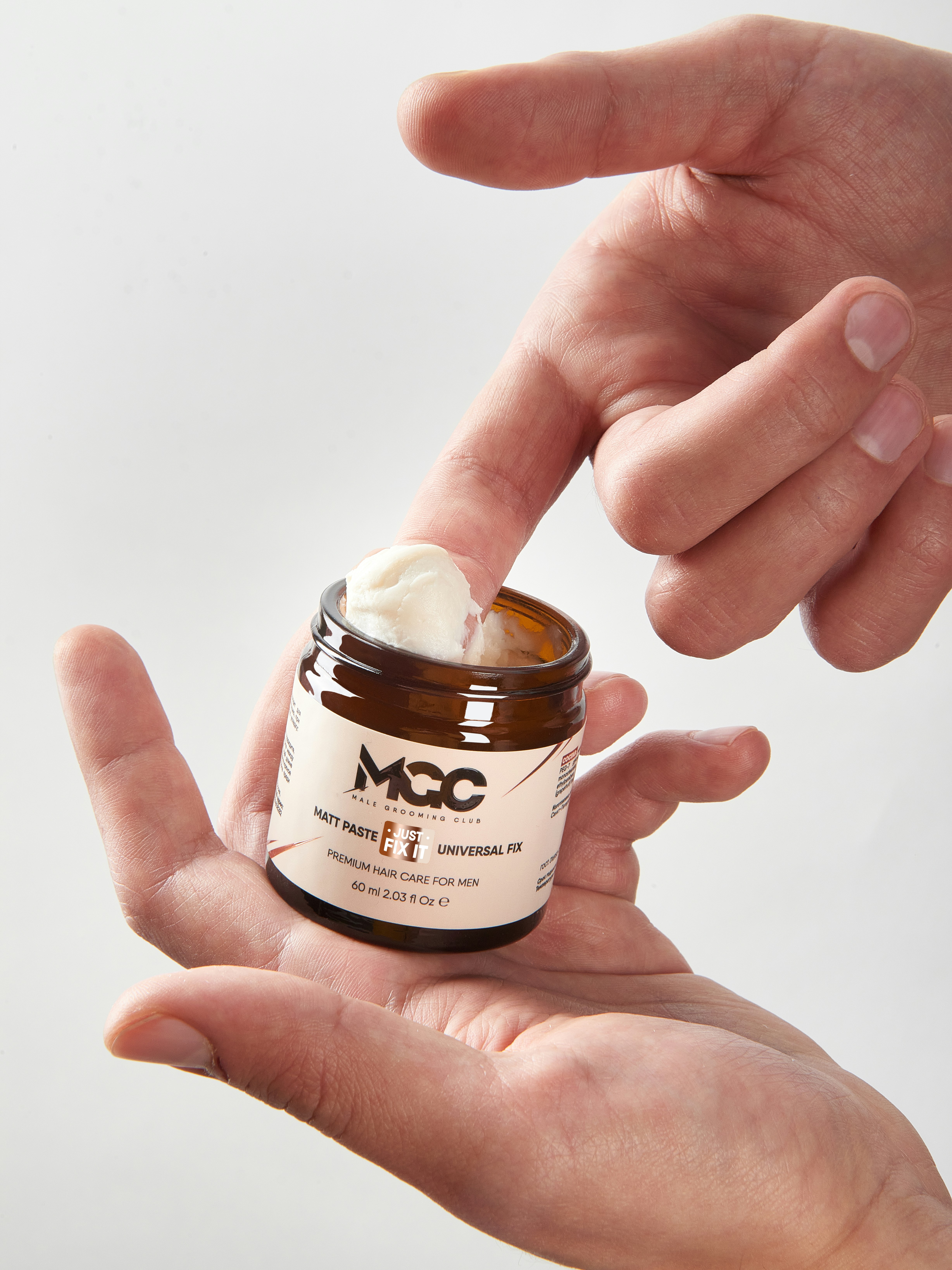 a hand holding a jar of peanut butter