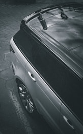 a black car parked on a brick road