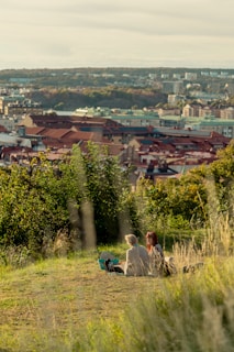 An elegant couple enjoying a sunset picnic on a hilltop with sweeping panoramic views of lush green valleys