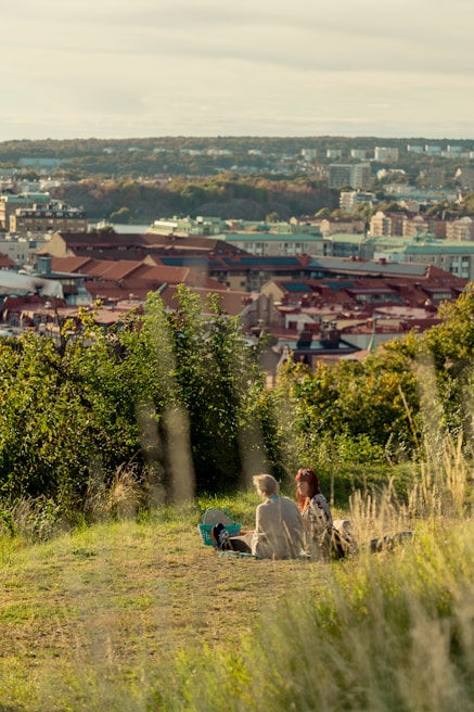 An elegant couple enjoying a sunset picnic on a hilltop with sweeping panoramic views of lush green valleys
