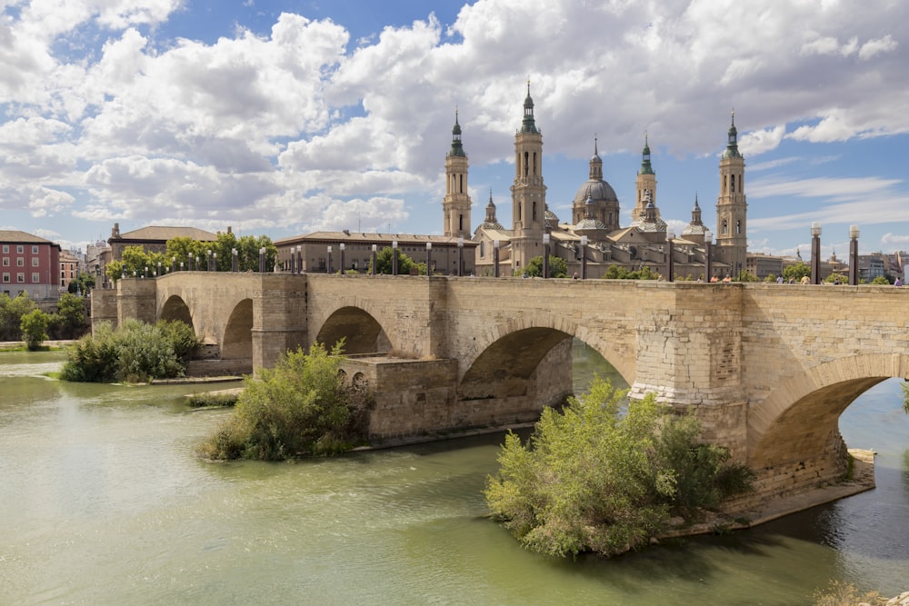 Puente de Piedra over a river leading to a large building with towers