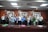 A diverse group of people smiling and shaking hands in a business meeting.
