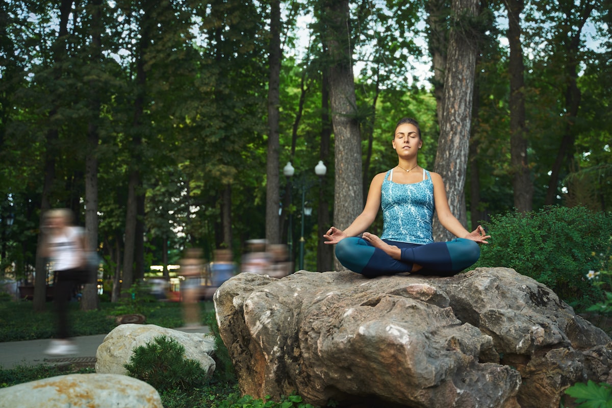 A woman meditating peacefully at sunrise