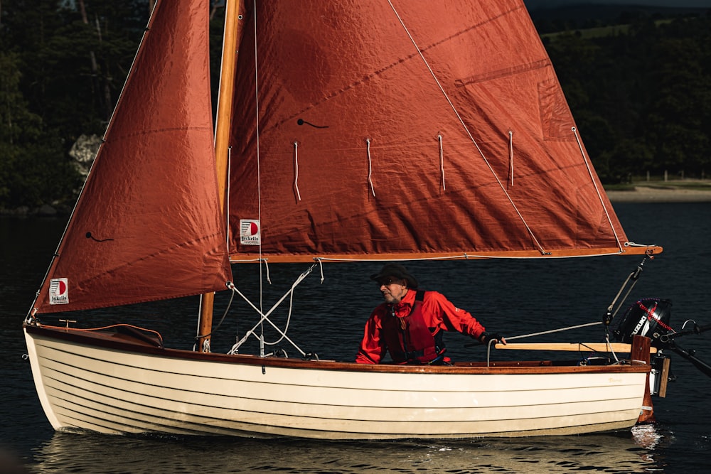 a person in a red jacket on a sailboat