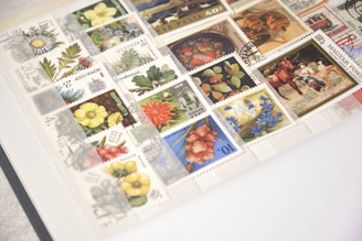 A collection of various collectible stamps displayed neatly in an album, featuring illustrations of flowers, plants, and scenes. The stamps are from different countries with a variety of colors and designs.
